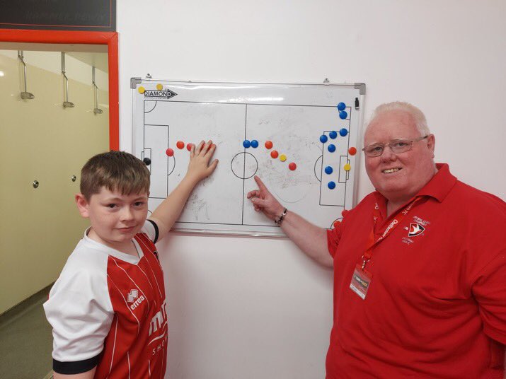 Dave Hardy, DLO at Cheltenham Town FC with Noah from Alderman Knight School - discussing tactics while on a tour of the Completely-Suzuki Stadium